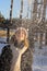 A young girl in beige mittens tosses snow and laughs