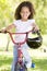 Young girl on bicycle outdoors smiling