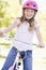 Young girl on bicycle outdoors smiling