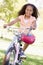 Young girl on bicycle outdoors smiling