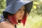 A young girl in a big hat collects berries in wooden baskets in the summer forest, collecting gifts of the forest