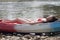 A young girl in bikini lying on the boat and sunbathing near the river, enjoying holidays in Laos