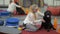 Young girl with black labrador relaxing on the floor after training in the gym