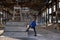 A young girl in a black mask in the destroyed building of the old factory. Consequences of the Apocalypse, epidemic, destruction