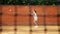 Young girl blocking the ball with the tennis racket during the training