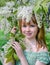 Young girl with the blossoming bird cherry branches