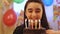 Young girl blowing candles on birthday cake