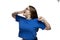 A young girl in a blue T-shirt sweetly yawns and stretches. Early morning rise and fatigue. Isolated on a white background