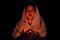 Young girl with candle light praying in dark night background. Woman person worship God with faith and belief. religion, christian