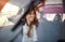 A young girl in a car on a roadtrip through countryside, shot through glass.