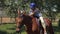 A young girl caresses a horse while riding