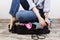 Young girl casually packs black suitcase