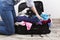 Young girl casually packs black suitcase