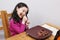 young girl with changing teeth is working on a large pork rib