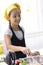 Young girl in a chef`s hat cooks in a large saucepan in a black