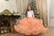 a young girl in a chic white with peach dress