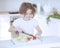 Young girl chopping tomatoes and making a salad in the kitchen