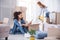 Young girl cleaning floor while her roommate looking at photo