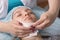 A young girl is cleaning the skin of her face at a cosmetologist. Facial cleansing and massage