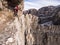 Young girl climbs via ferrata high in the mountains