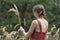 Young girl collects ears of wheat. Back view