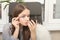 A young girl combs and shares her eyelashes with a special brush