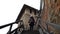 A young girl comes down the stairs in an old castle.