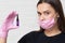 Young girl cosmetologist and brow specialist in a mask and protective gloves,