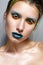 Young girl with creative multi-colored make-up. Bright neon colors. Turquoise lips and shining skin. The cosmic image. Beauty of t