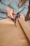 Young girl cuts wrapping paper with scissors for making a gift