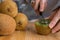 Young girl cutting a kiwi