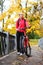 Young girl cyclist with bike on bridge in autumn park