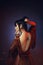 Young girl with dark blue hair and a bang in a long red dress with open naked bare back. a tatoo picture lotus with a