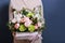 a young girl in a delicate dress is holding a beautiful composition of flowers in a box, created by a florist. the concept of a