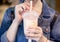 Young girl in denim jacket is drinking brown sugar flavored tapioca pearl bubble milk tea with glass straw in night market of