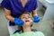 young girl dentist begins treatment of all diseased teeth in her regular client.