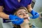 young girl dentist begins treatment of all diseased teeth in her regular client.
