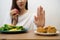 Young girl on dieting for good health concept. Close up female using hand reject junk food by pushing out her favorite fried