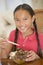 Young girl in dining room eating chinese food