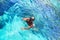 Young girl with diving mask and snorkel dives in clear blue sea water, adult woman in white bikini swims in turquoise clean water