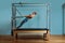 A young girl does Pilates exercises with a bed reformer, barrel machine tool. Beautiful slim fitness trainer on the