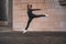 Young girl doing a gymnastic jump on the street - urban contemporary dance concept