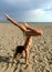 Young girl doing handstand exercize on the beach