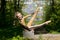 Young girl doing strength gymnastic exercises workout in a beautiful suit outdoors in a park.