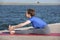 Young girl doing yoga or fitness exercise outdoor in nature with beautiful lake. Meditation and Relax concept