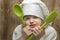 Young girl dressed as chef with green silicone spoons on wooden