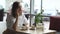 Young girl drinking coffee and talking on mobile phone in cafe. business woman on lunch break