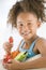 Young girl eating bowl of vegetables in living roo