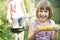 Young Girl Eating Sweetcorn At Family Barbeque