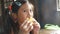 A young girl eats corn with day light